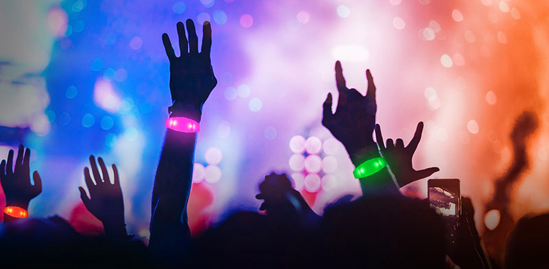 Foule portant des bracelets LED synchronisés lors d'une soirée Party LED